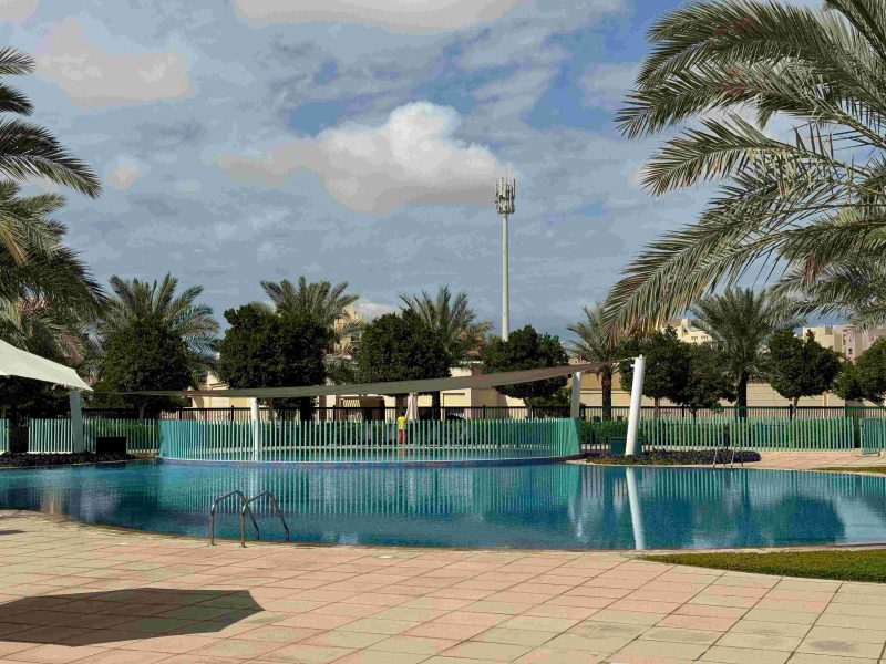 Swimming pool in the community with poolside lounge chairs